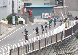 声援を受けながら、坂を下りてくるライダーたちの写真