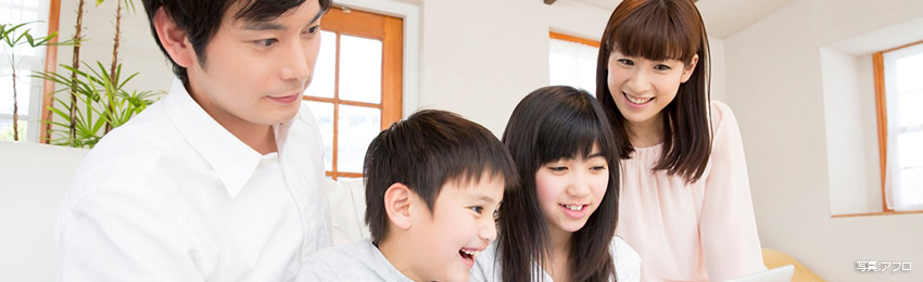 サービスの安心・安全。家族をイメージする大人の男女と子ども2人が何かを見つめている写真。