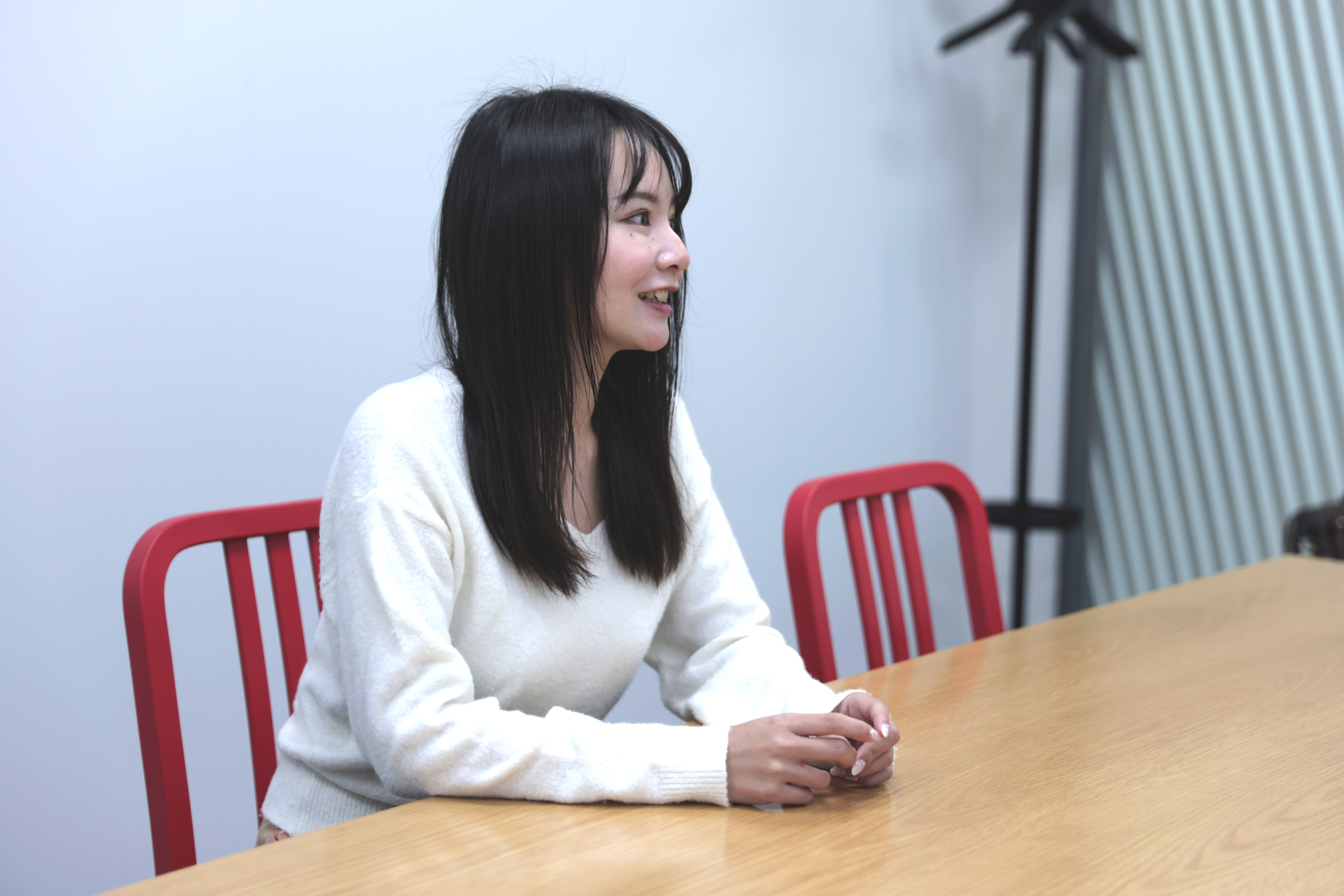 石田が椅子に座りながら、入社前の経験についてのインタビューに答えている様子の写真