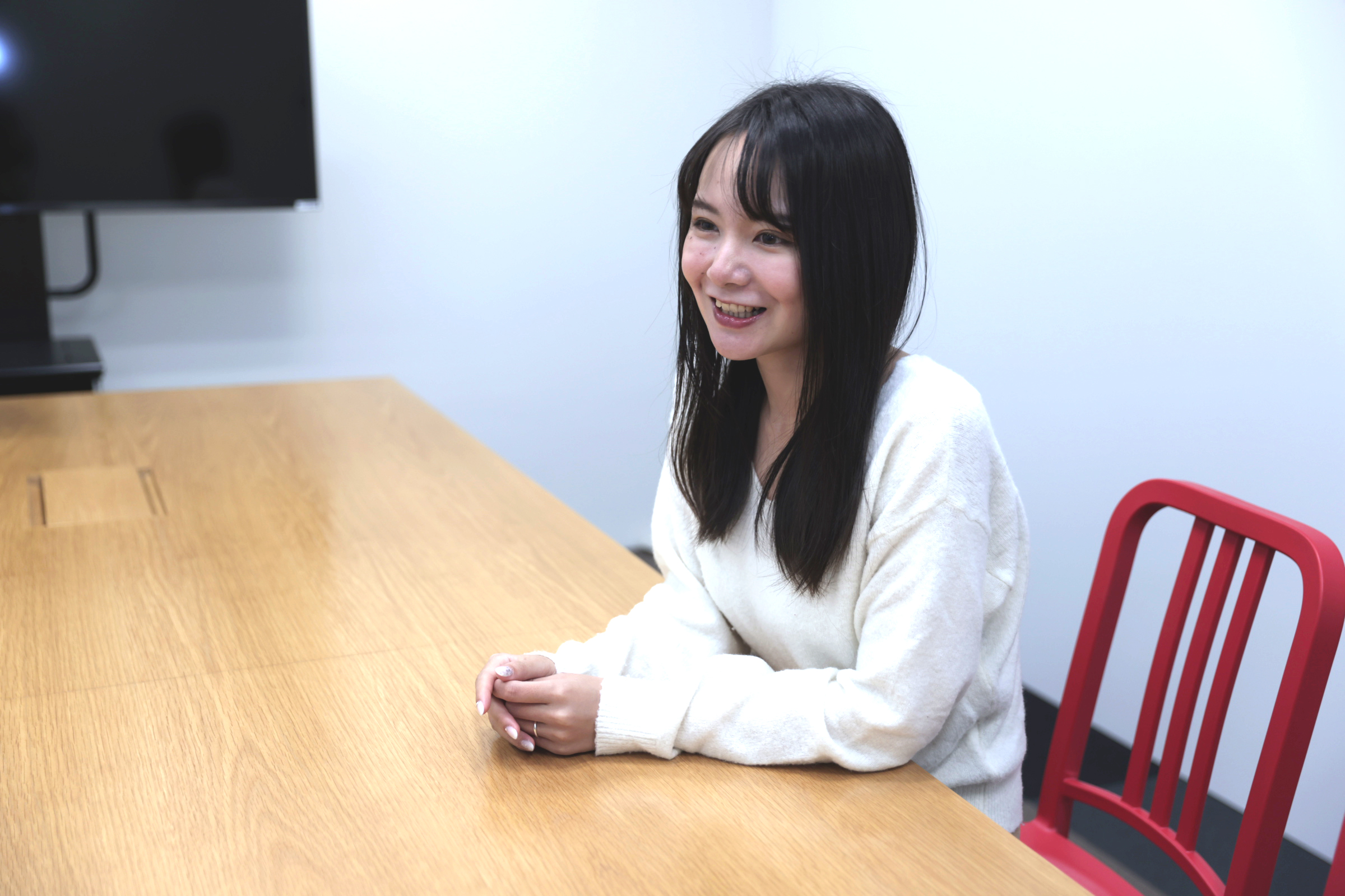 石田が椅子に座りながら、仕事のやりがいなどについてインタビューに答えている様子の写真