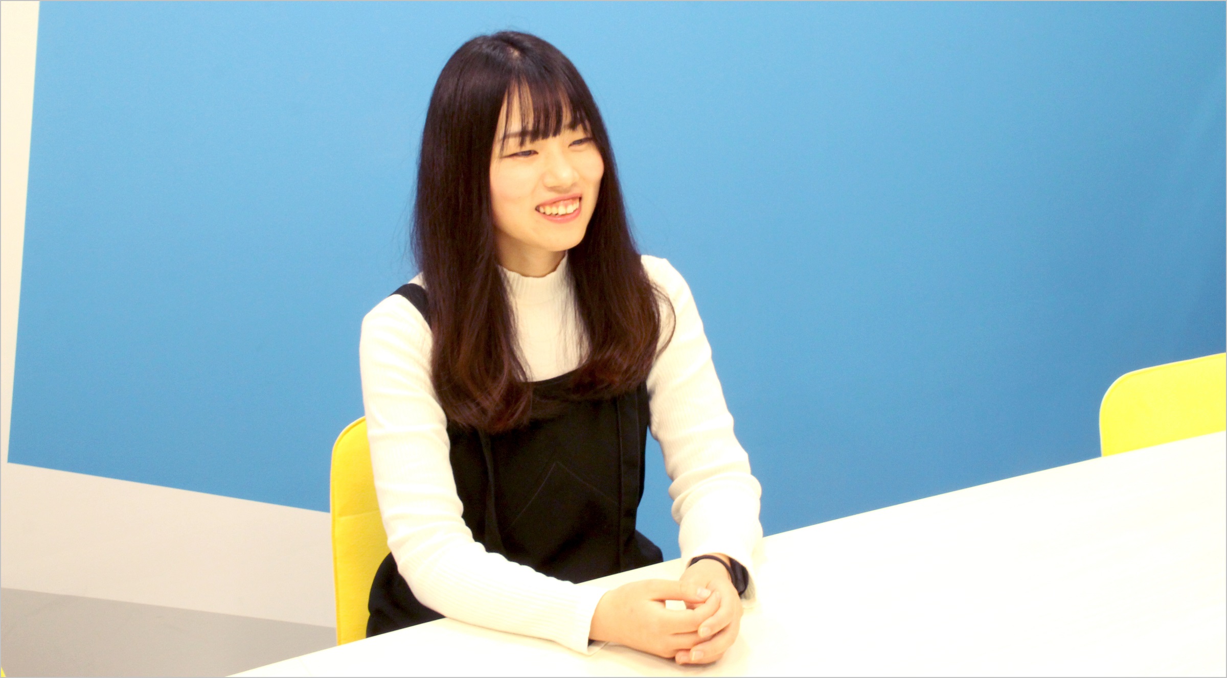 松井が椅子に座り笑顔でインタビューに答えている様子の写真