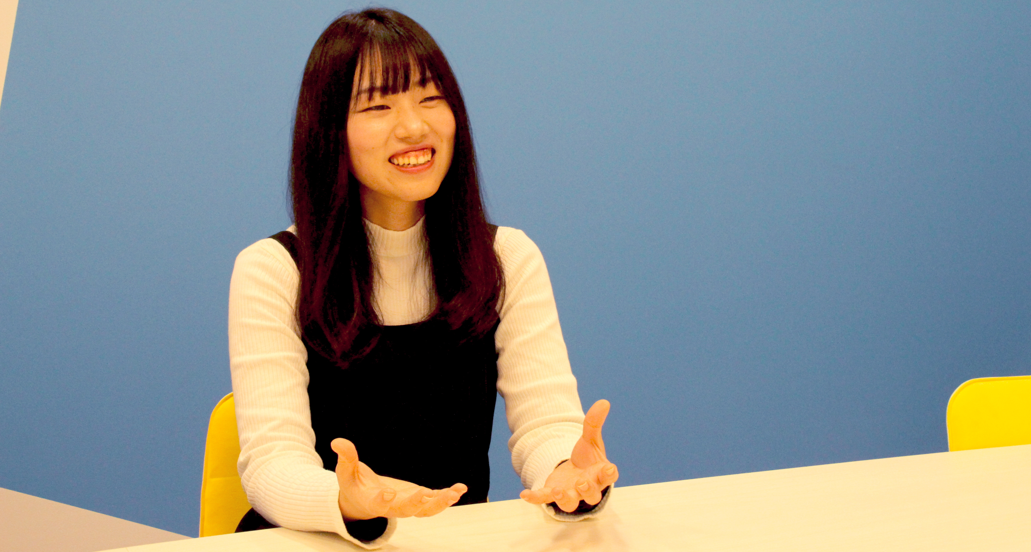 松井が椅子に座り笑顔でインタビューに答えている様子の写真