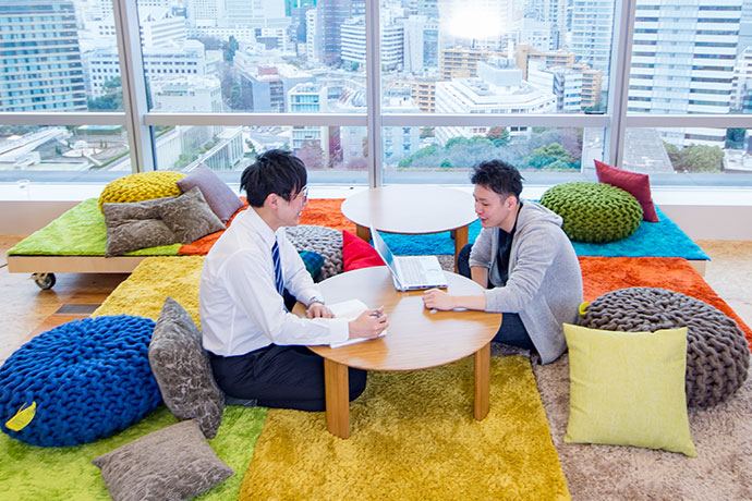 社員食堂BASEの窓際のスペースで話し合う社員の写真