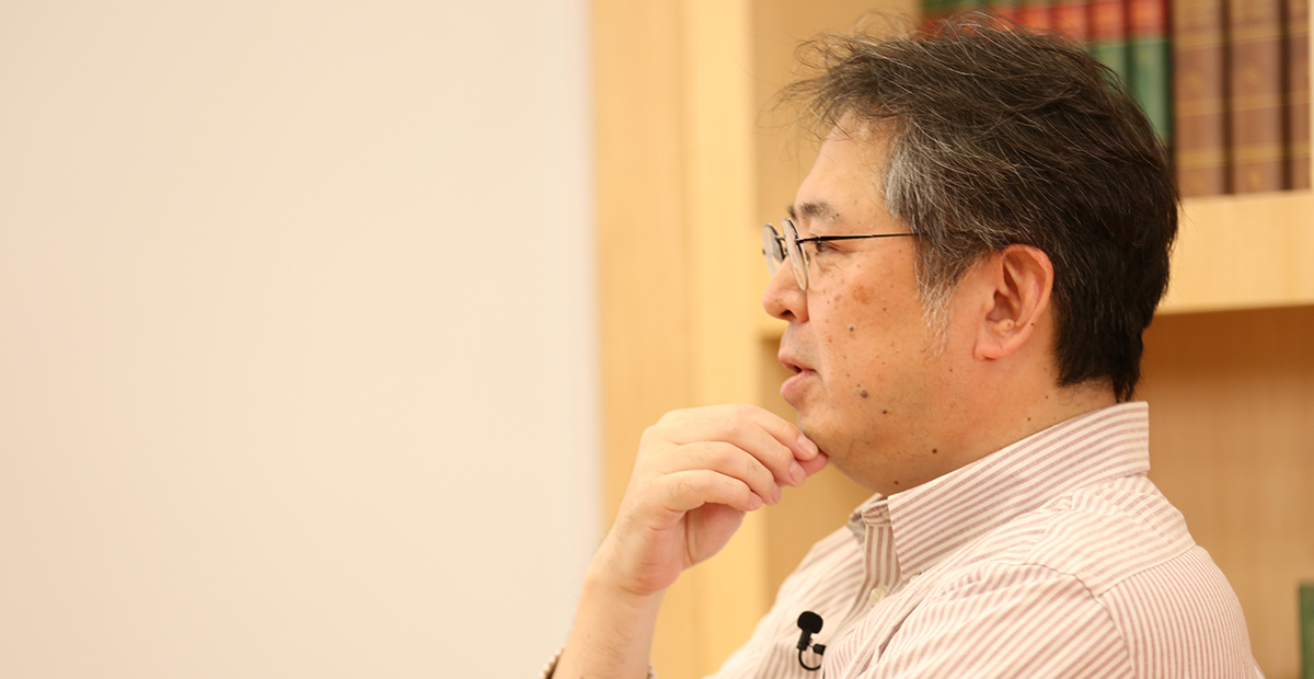 眼鏡をかけた男性が考え込んでいる横顔。