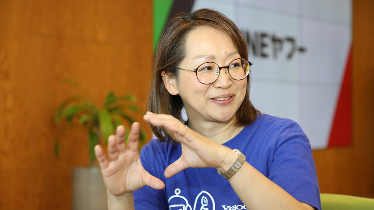 メガネをかけた女性が手を使って話している様子。