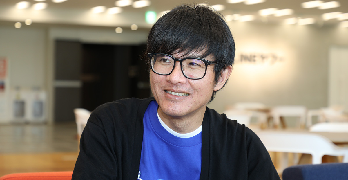 メガネをかけた男性が微笑んでいる。