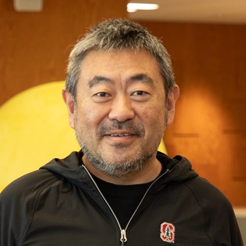 男性がカメラに向かって微笑んでいる。