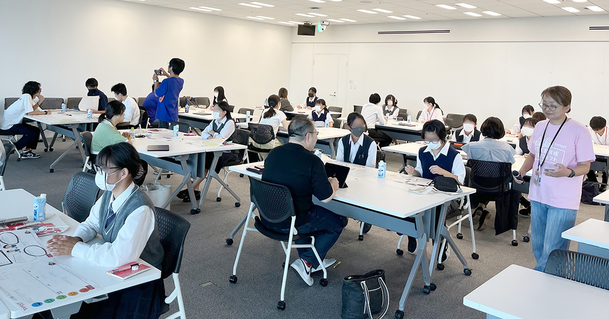 教室で学生たちがグループに分かれて活動している様子です。