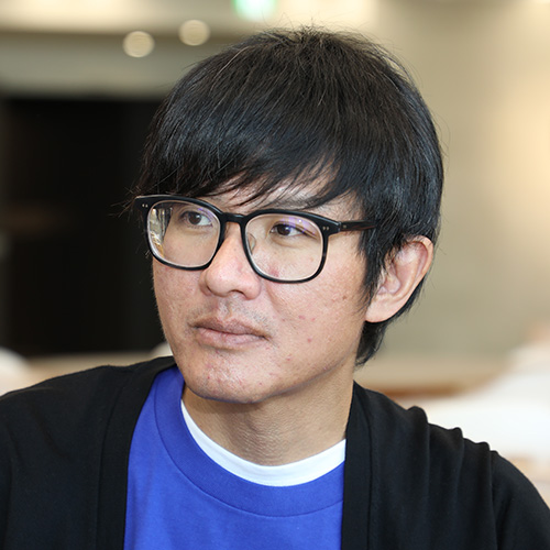 眼鏡をかけた男性が何かを考えている様子です。