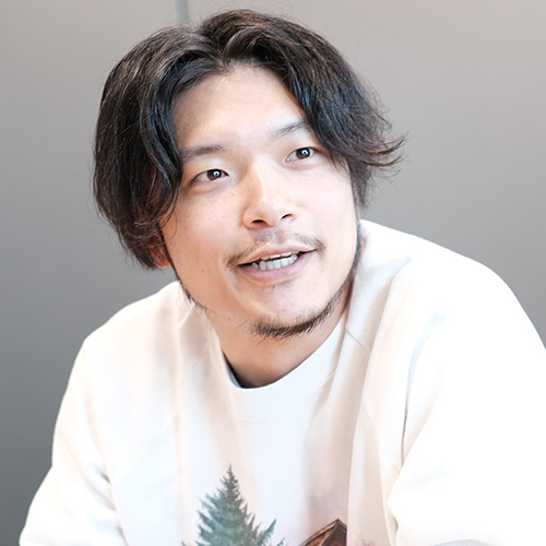 白い服の男性が微笑んでいるポートレート。
