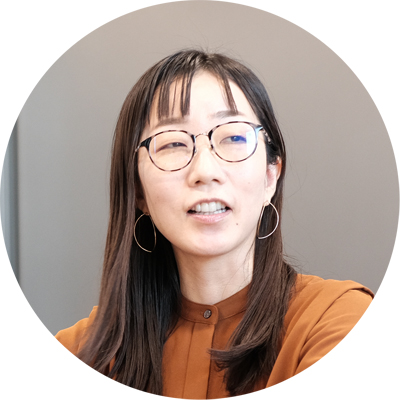 メガネをかけた女性が、何かを考えながら話している。