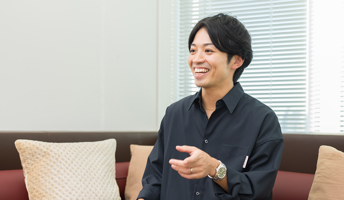 A man is shown smiling and talking on a sofa, creating a friendly atmosphere.