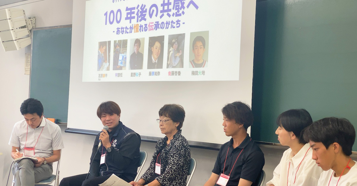 パネルディスカッションで話す参加者たち。スクリーンに「100年後の共感へ」の文字。