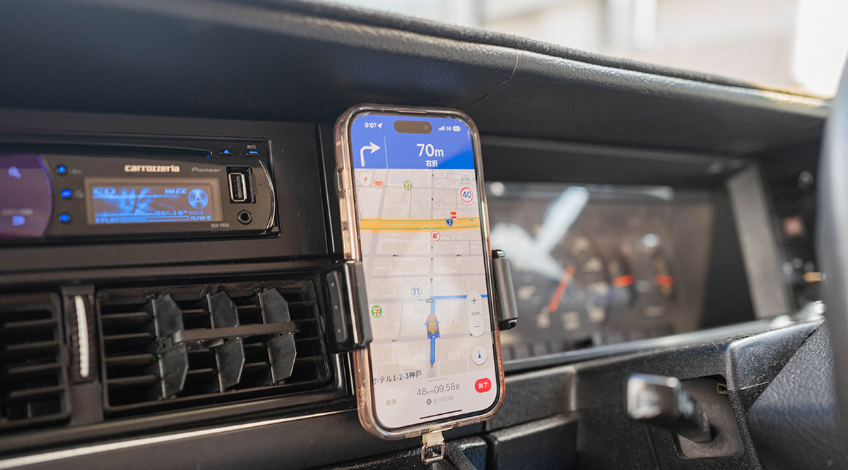 車内に設置されたスマートフォンがナビゲーションアプリを表示し、目的地までのルートを案内している。