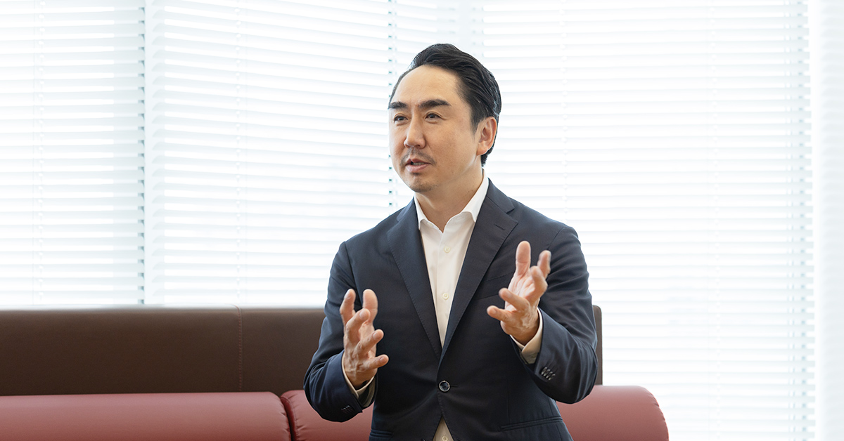 男性がオフィスで話している様子。手を動かしながら、真剣に説明している姿が印象的。
