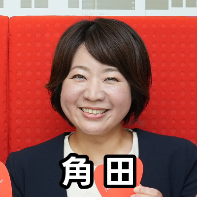 女性が笑顔で座っており、「角田」と書かれたテキストが重ねられています。