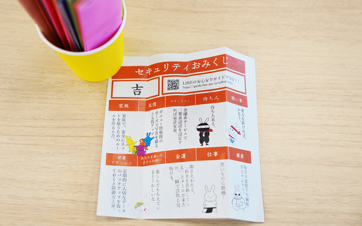 カラフルなペンが入ったカップと「セキュリティおみくじ」がテーブルに置かれています。