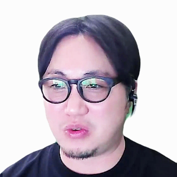 黒いシャツを着た眼鏡の男性がヘッドセットをつけて話しています。
