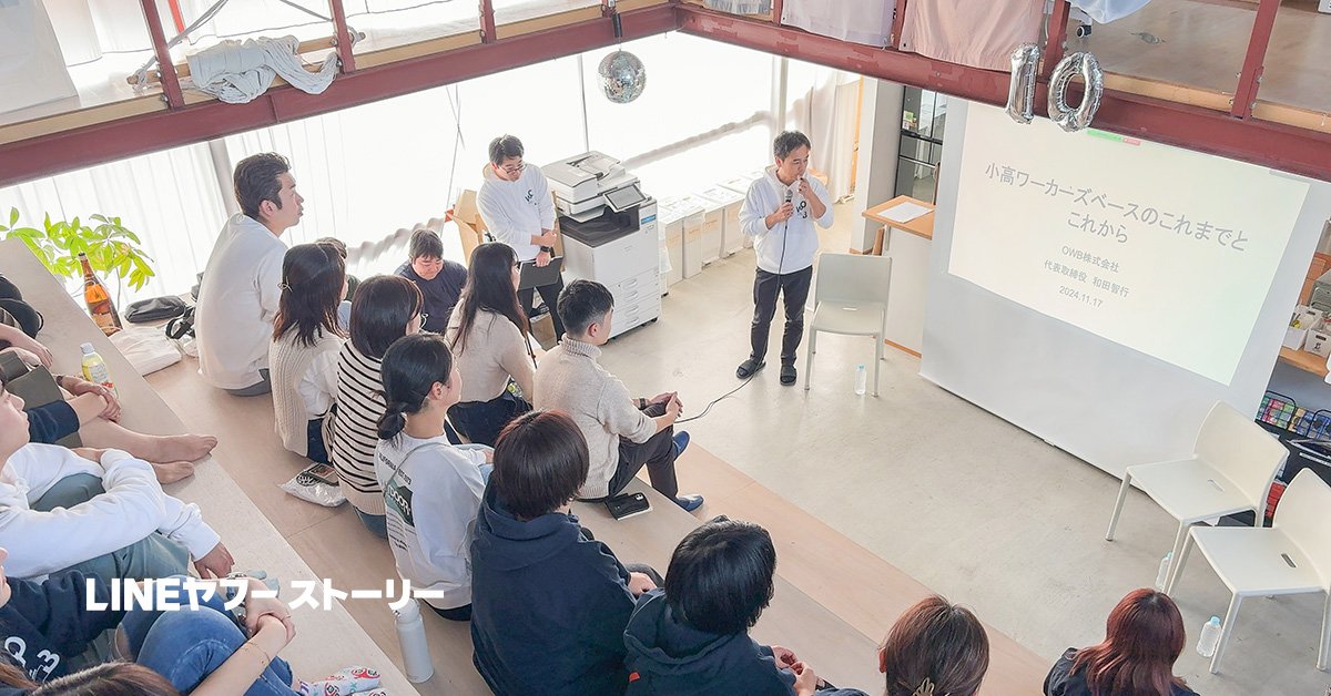 階段状の座席に人々が座り、プレゼンテーションを聞いています。スピーカーの和田さんがスクリーンの前で話をしています。「LINEヤフー ストーリー」と書かれています。