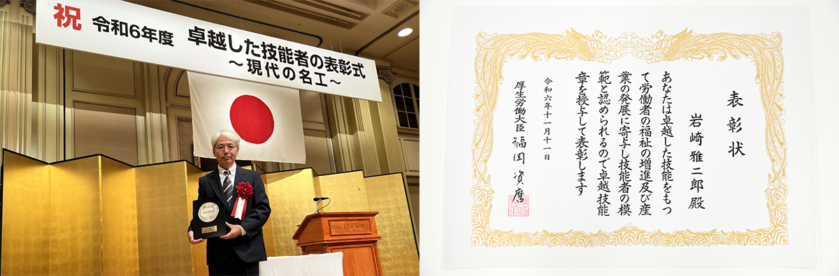 岩崎が「卓越した技能者の表彰式」で賞を受け取っています。背景に日の丸があり、右側に表彰状が写っています。