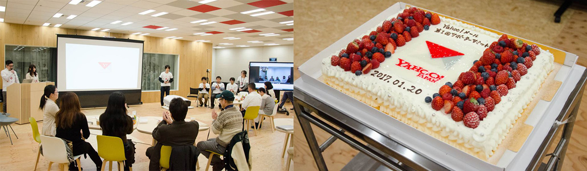 会議室でプレゼンテーションが行われています。大きなケーキが用意されており、イベントが祝われています。