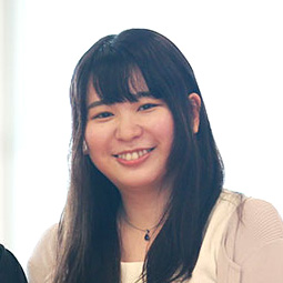 女性が微笑んでカメラを見ています。明るい雰囲気で、リラックスした様子です。