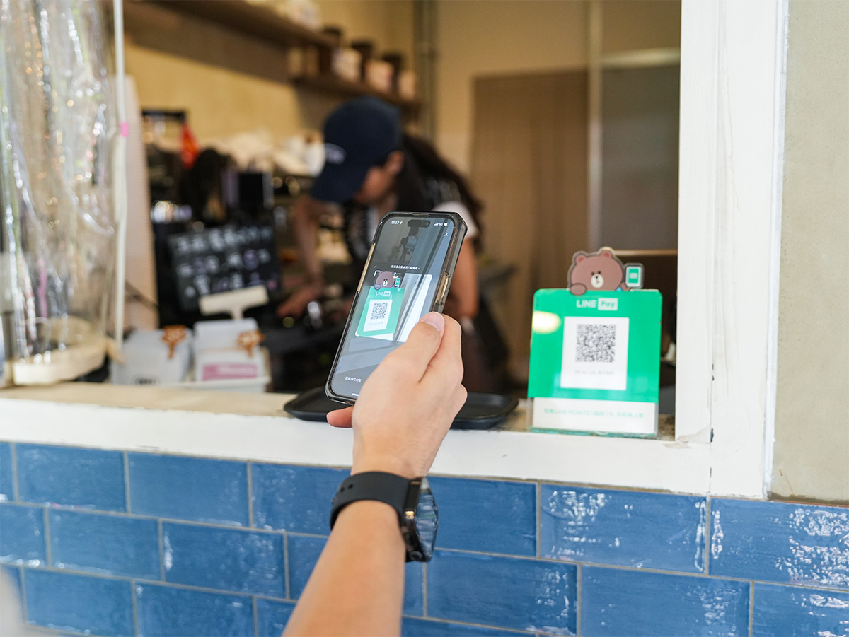 スマートフォンでQRコードをスキャンしている手元の写真です。LINE Payでの支払いを行っています。