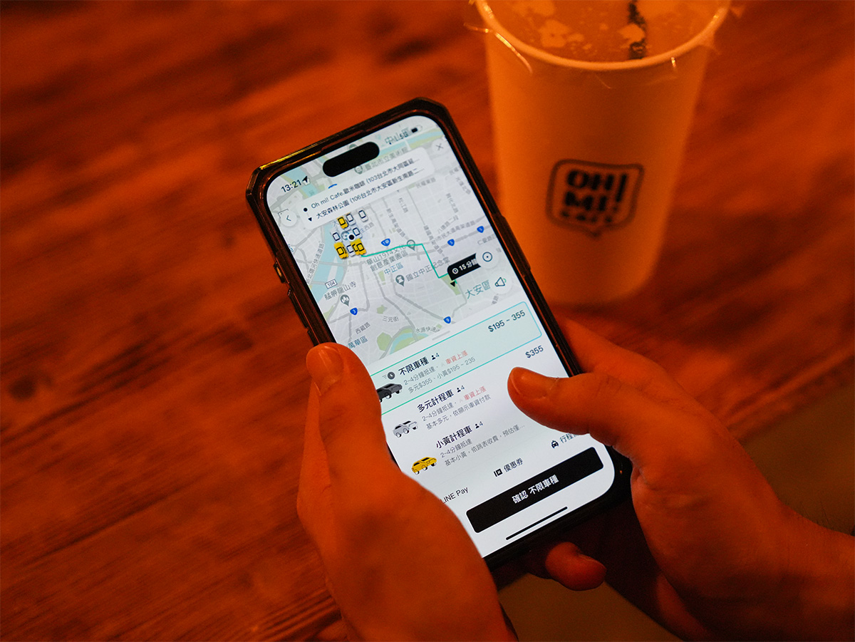 スマートフォンで地図アプリを使用している手元の写真です。近くには飲み物のカップが置かれています。