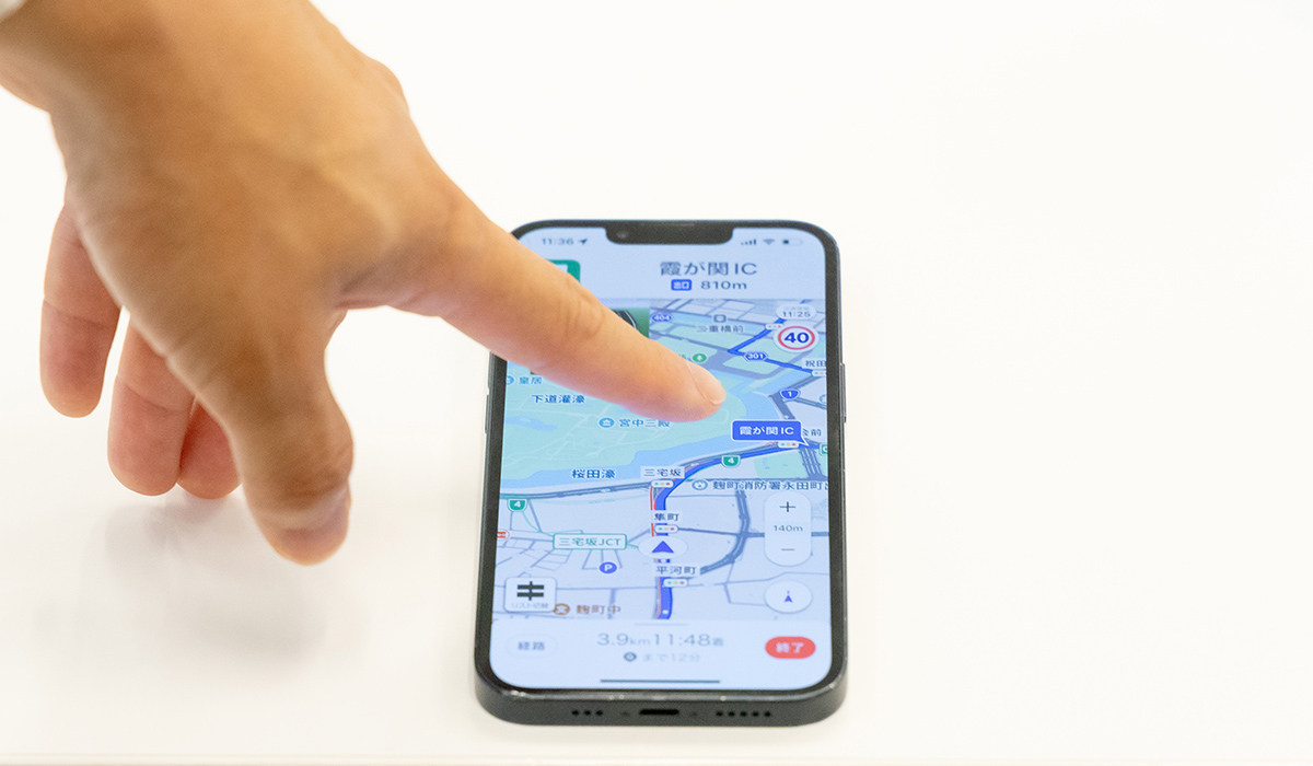 指がスマートフォンの地図アプリを操作している写真です。地図上の情報を指で指し示しています。