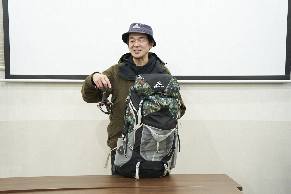 アウトドア風の服装をした5歳さんが、大きなバックパックを持ってポーズを取っています。