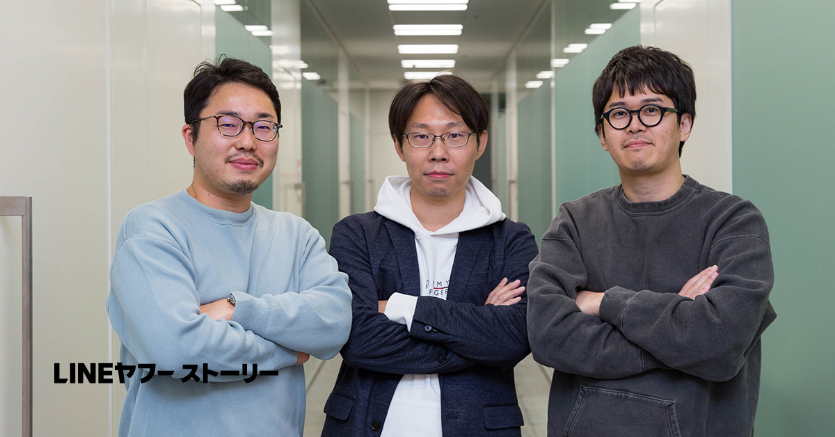 3人の男性がオフィスの廊下で並んで立っています。画像の左下に「LINEヤフー ストーリー」と書かれています。