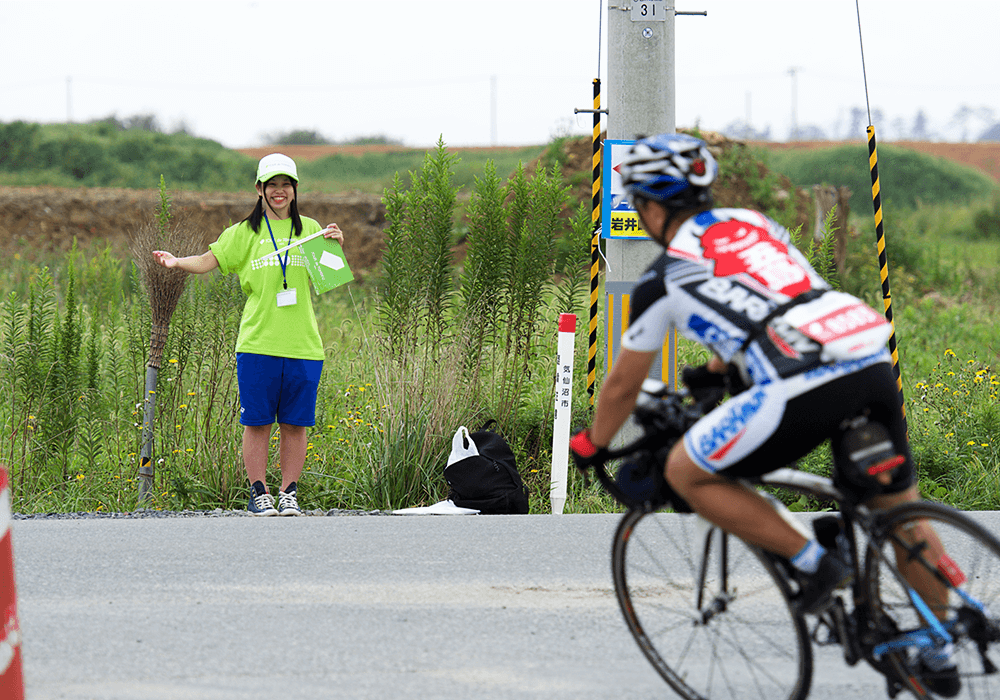 写真:コース上に立ってライダーを誘導する立哨クルー