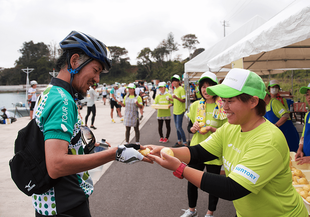 写真:エイドステーションでライダーに料理を提供するクルー