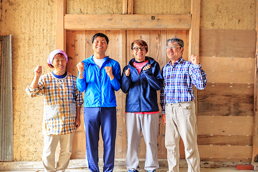 写真:お世話になった一般の民家の方と笑顔撮影している様子、民泊を利用した昨年の参加者