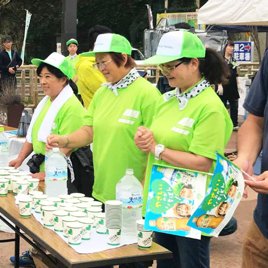 応“縁”バンダナを首に巻いた3人のボランティアスタッフの写真