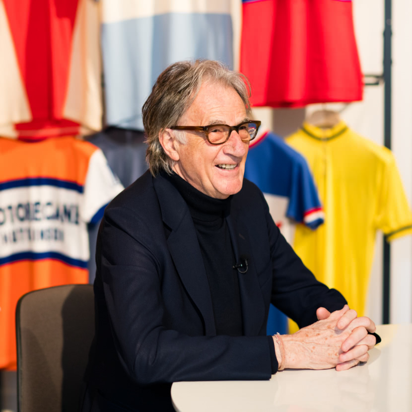 手を組み笑顔で語るポール・スミス氏の写真