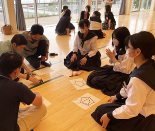 高校生の地域での学びを支える気仙沼学びの産官学コンソーシアムのようす。床に座って輪になってワークをしている学生と大人の写真