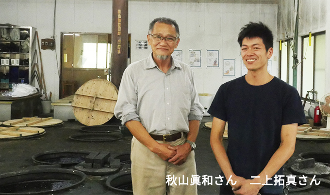画像:工房で並んで微笑む秋山眞和さんと二上拓真さん
