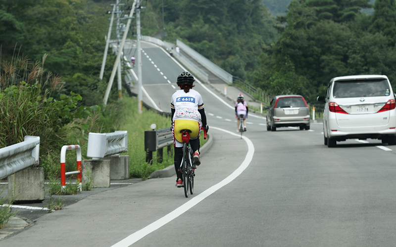 交通規制されていない公道のコースを走るライダー
