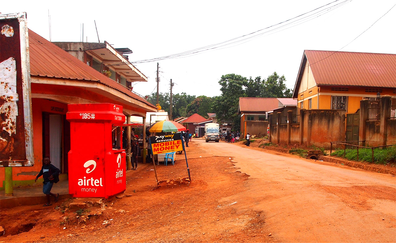 ウガンダの首都カンパラ近郊のナンサナ村の裏通りにも「モバイルマネー」の看板が