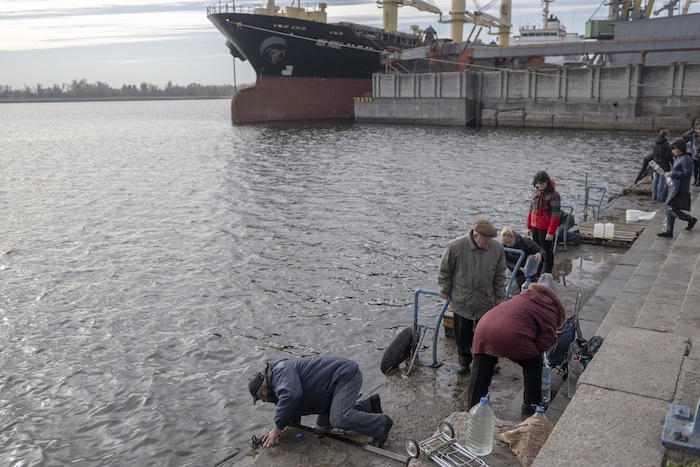 ウクライナ・ヘルソンのドニプエル川で掃除などに使うための水をくむ人（2022年11月19日撮影）。(c)BULENT KILIC / AFP
