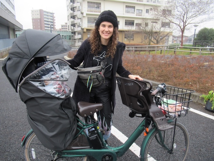 市職員のカンパで贈られた電動アシスト付自転車で子どもたちを保育園に送る＝鎌ケ谷市