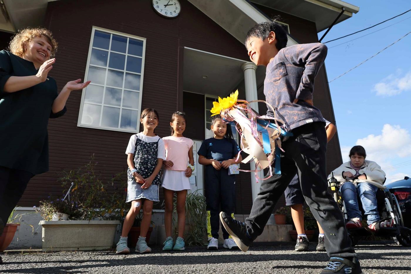 手芸教室の後、子どもたちと踊りを交えたゲームを遊ぶむマリナ・イバシェンコさん（左）＝静岡県御殿場市で2023年10月29日