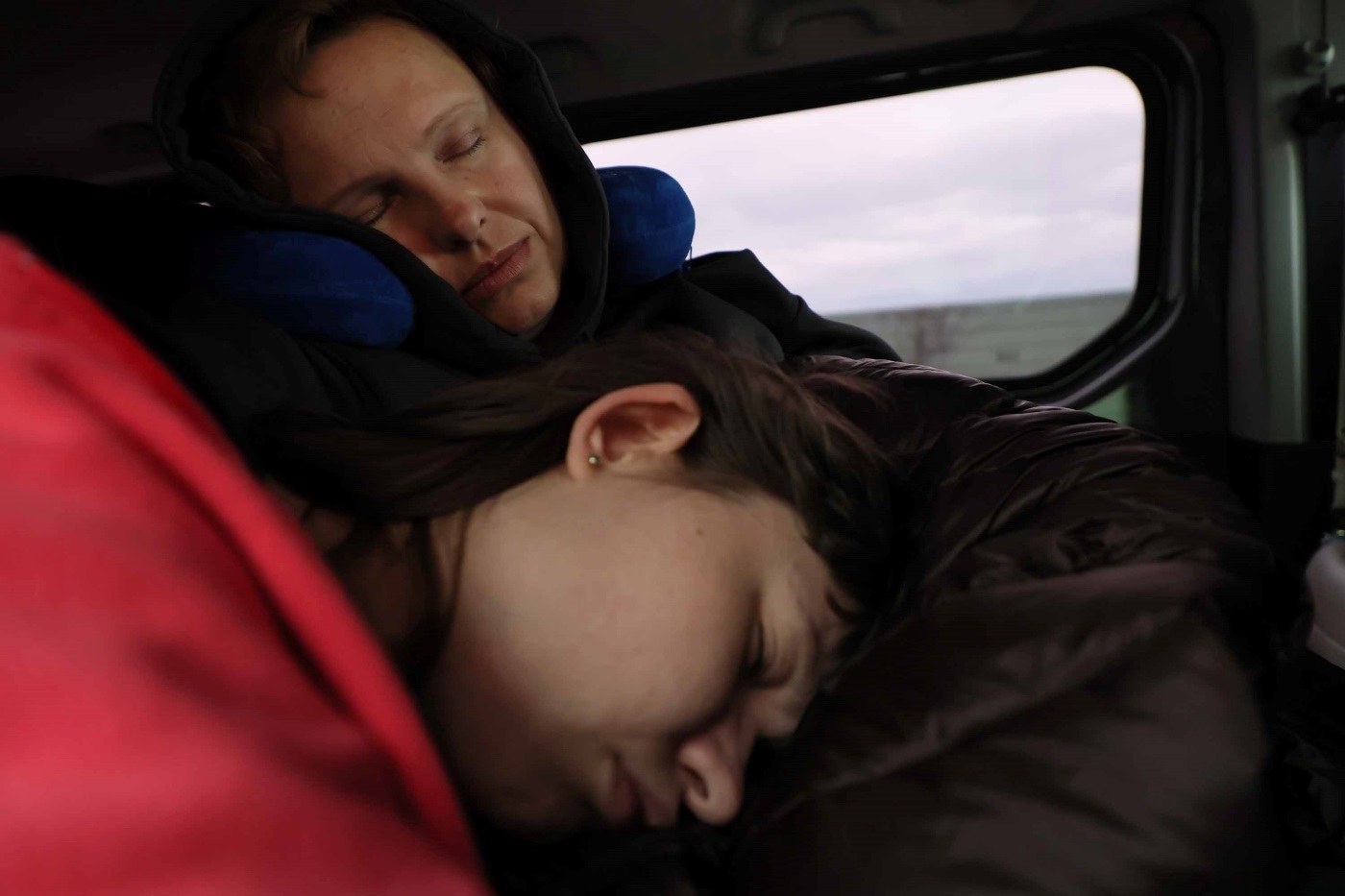 友人の運転する車でウクライナ国境へ向かう道中、眠る（手前から）マルタ・イバシェンコさんと母マリナさん＝ポーランド東部で2023年11月3日