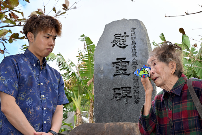 「南洋群島」で犠牲になった人々の慰霊のために建立された碑の前で、サイパンでの戦争体験を語る横田チヨ子さん（右）と国際旅行社の我如古涼太さん＝2024年2月、沖縄県那覇市識名（竹尾智勇撮影）