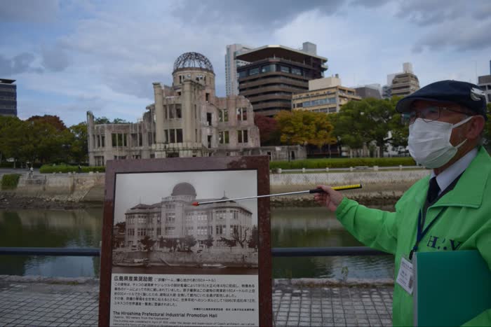当時の広島県産業奨励館の写真と比較しながら、いまの原爆ドームについて説明する多賀さん。原爆の威力が想像できます（2021年11月、水野梓撮影）