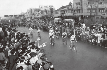 写真：1952年6月4日の第1回大会で、詰め掛けた観衆の拍手と歓声に送られながら国鉄仙台駅前から出発する選手たち