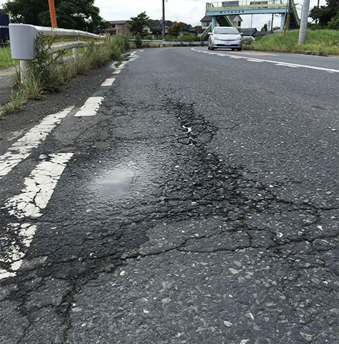 路面が割れてうねりが生じている様子