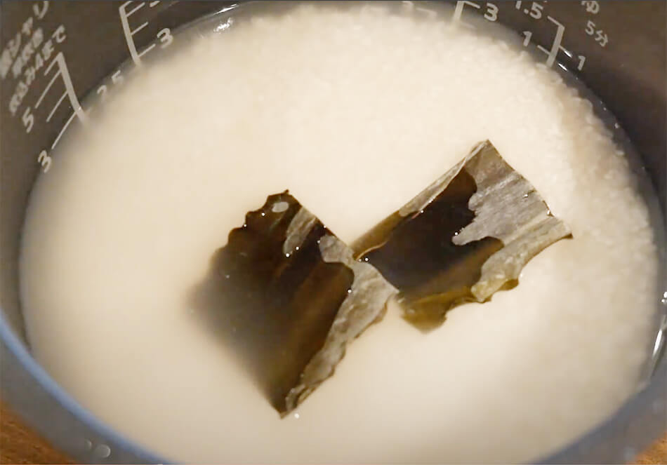 米を研ぎ、炊飯器で水(460ml)に30分ほど浸水させる。昆布を入れておく