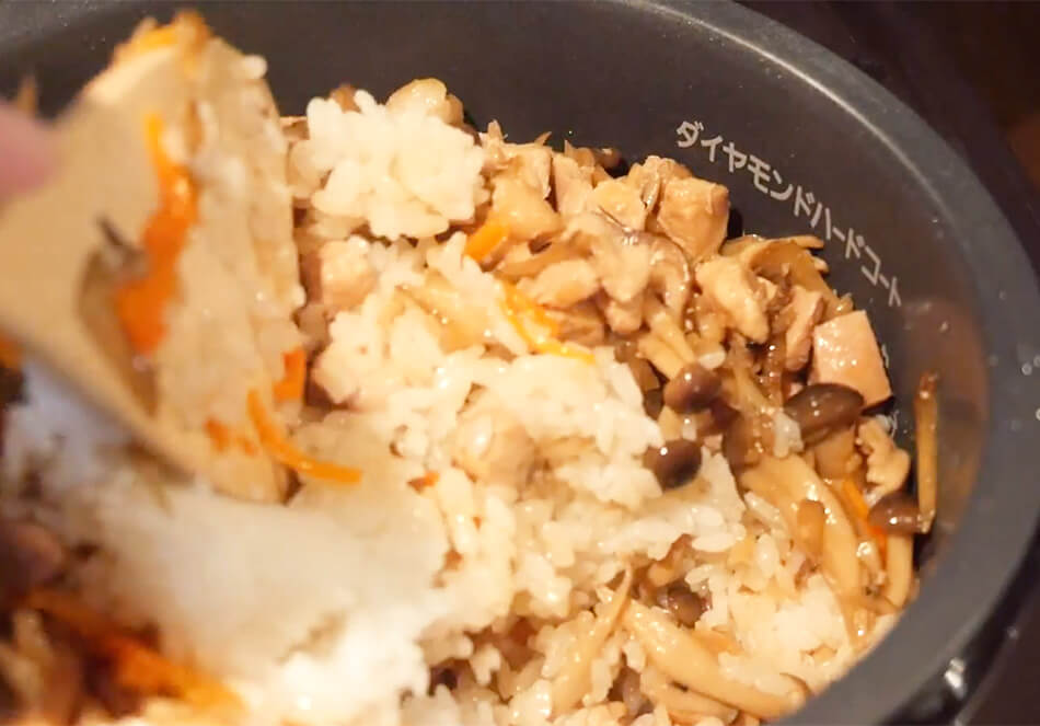 ごはんが炊き上がったら、煮込んだ具材と煮汁を入れ、色づきがまんべんなくなるように、切るように全体を混ぜる。炊飯器の再加熱、または、(再加熱モードがない場合は)炊飯を再度押し、蒸らし終わったらできあがり。